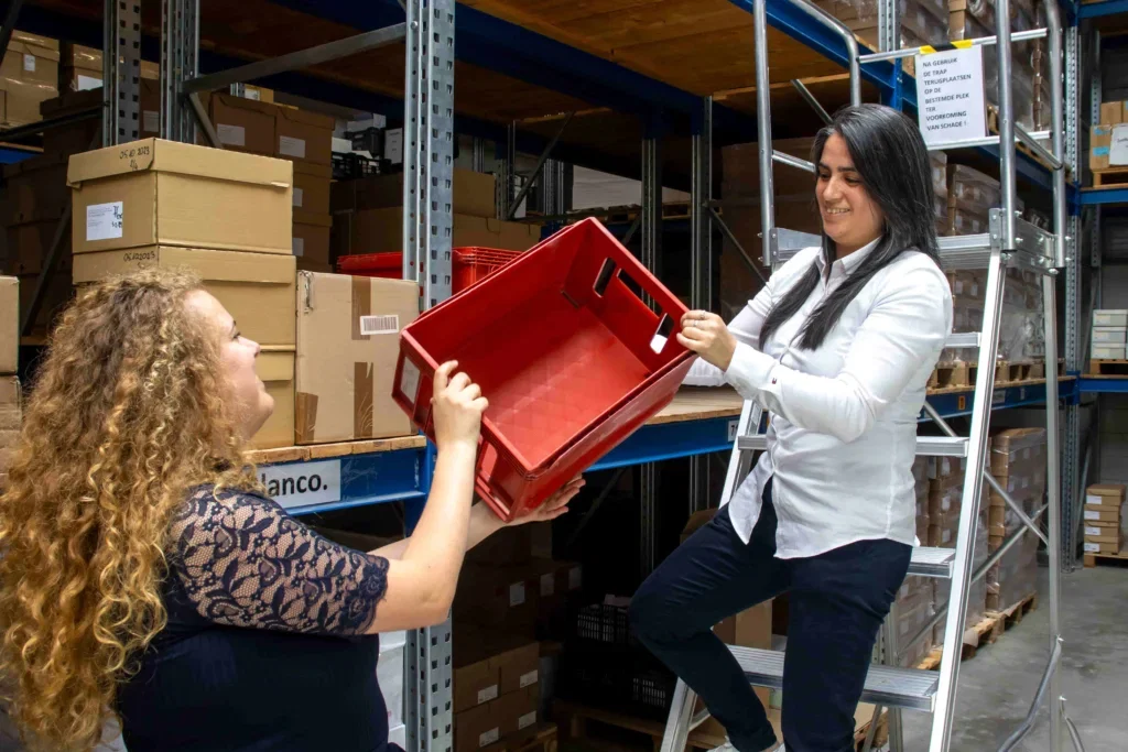 Twee medewerkers aan het werk in het magazijn Twee medewerkers aan het werk in het magazijn