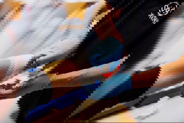 Arm in verband door blauwe handschoenen Arm in verband door blauwe handschoenen